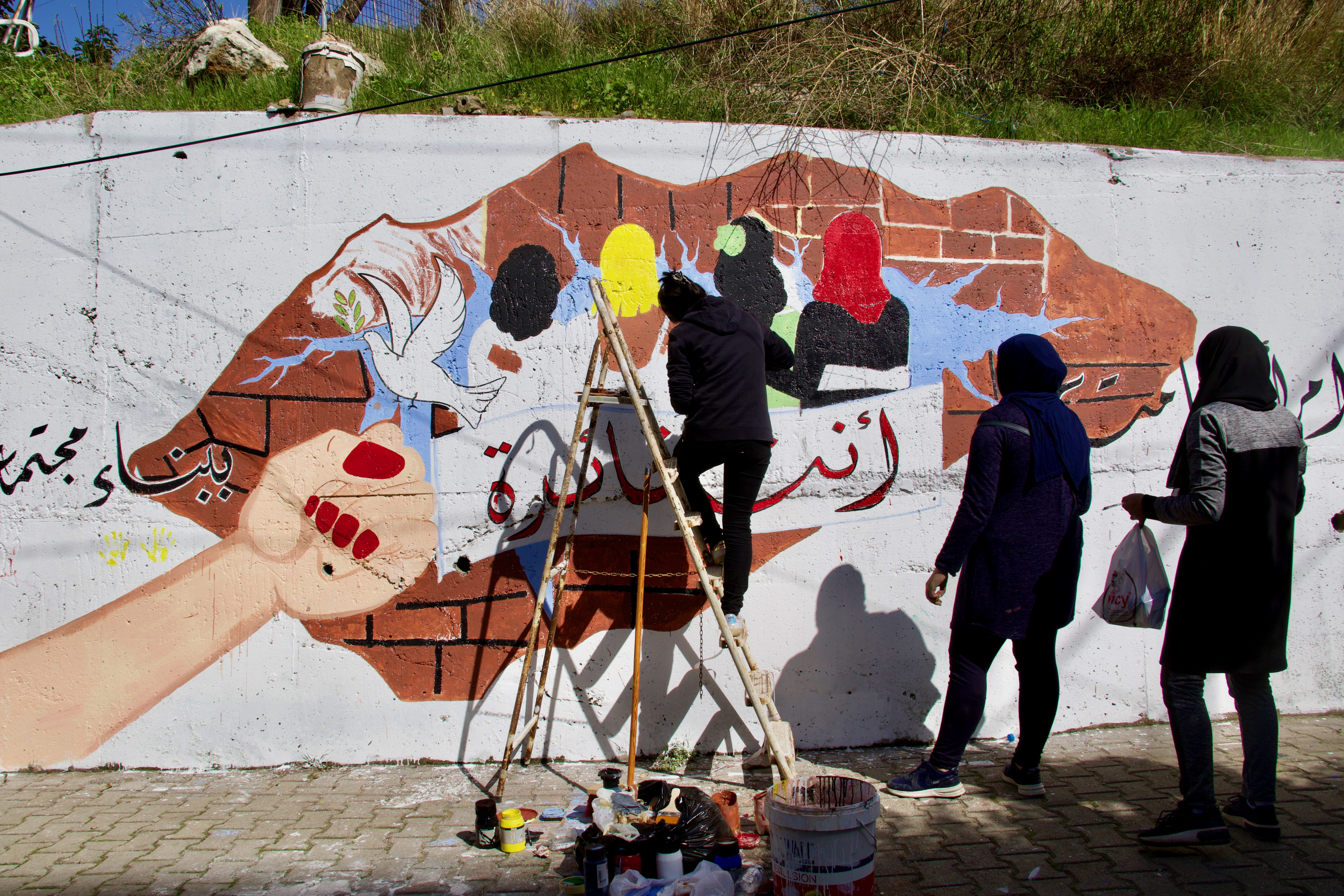 View from the exchange day (March 8 celebrating International Women’s Day) during which 45 women participants in the project executed a large mural in the street separating Bab al Tebbeneh and Jabal Mohsen, Tripoli, Lebanon. Photo: International Alert/UN Women