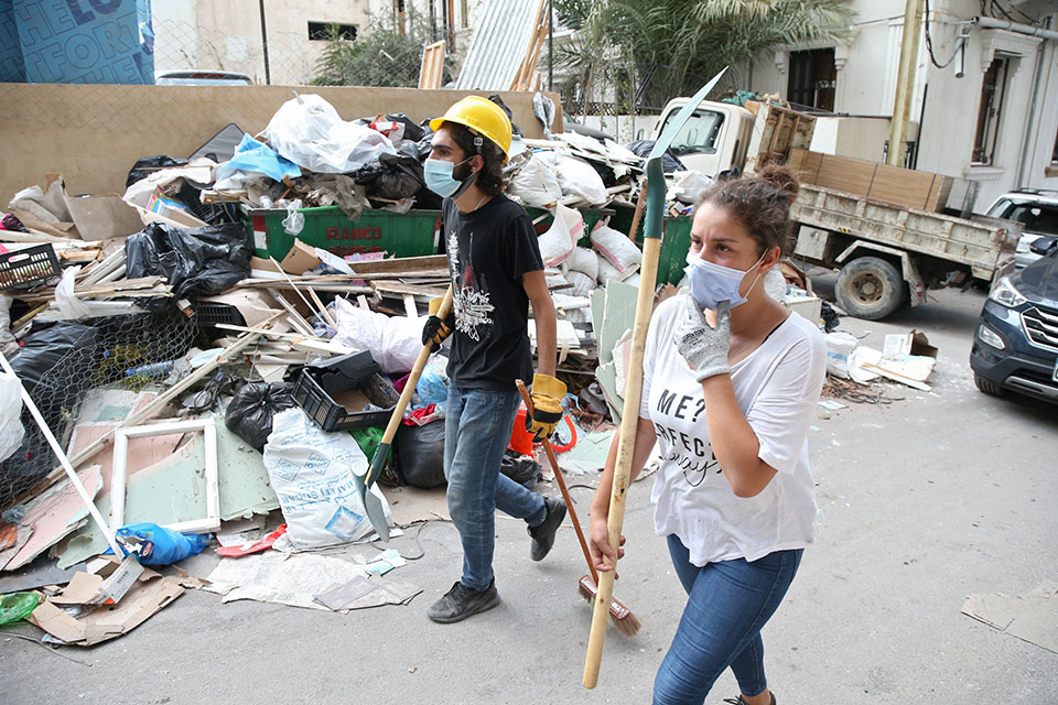 صورة لشابة وشاب لبنانيون يتعاونون لتنظيف الشوارع بعد انفجار بيروت. الجميزة، بيروت، 6 آب/ أغسطس 2020. تصوير: دار المصور