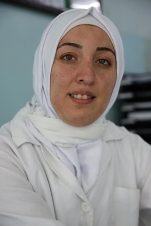 Rim Al Khalaf, a Syrian refugee in Lebanon, is providing nursing care for elderly patients during the COVID-19 pandemic. Photo: UN Women/Dar Al Mussawir