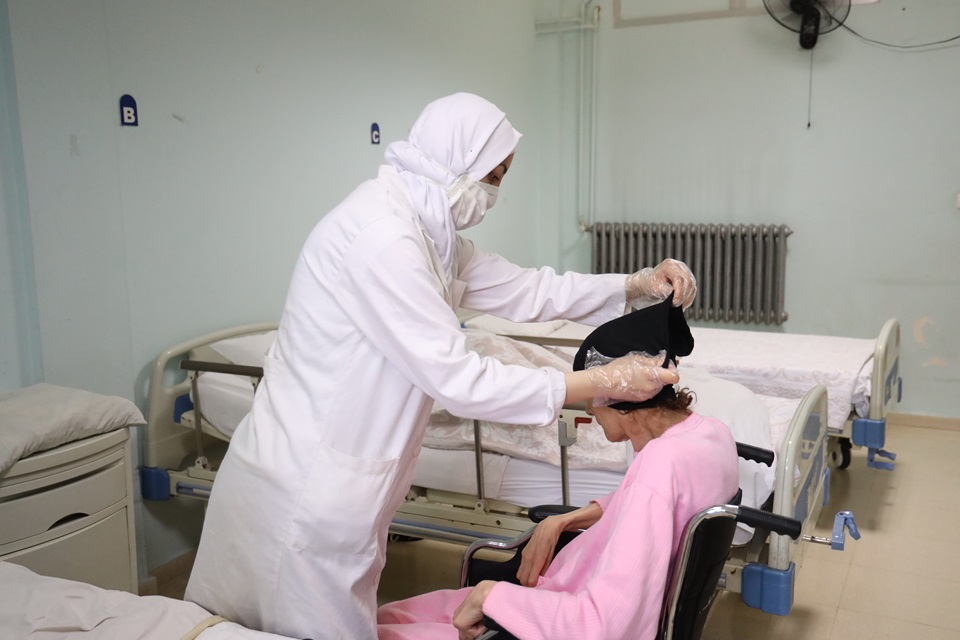 Rim caring for a patient. Photo: UN Women/Dar Al Mussawir.