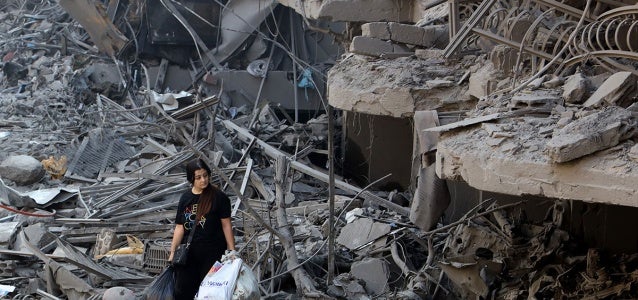 On 29 September 2024 a woman in Beirut, Lebanon walks among the debris of buildings destroyed by airstrikes.